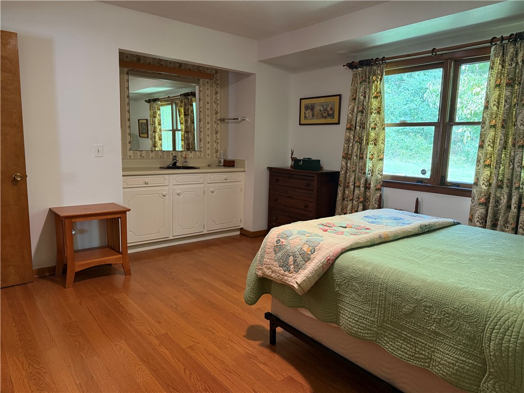 407 Seawright Drive Pendleton, SC 29670 - Photo 11 of 29 Warm wood flooring and an integrated vanity alcove define this comfortable bedroom space.