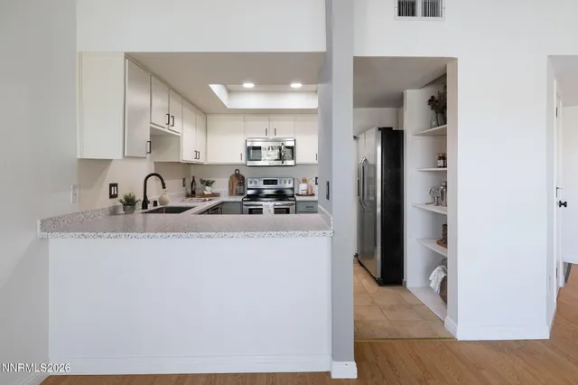 a kitchen with stainless steel appliances granite countertop a refrigerator and a sink