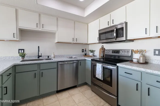 a kitchen with cabinets stainless steel appliances and sink