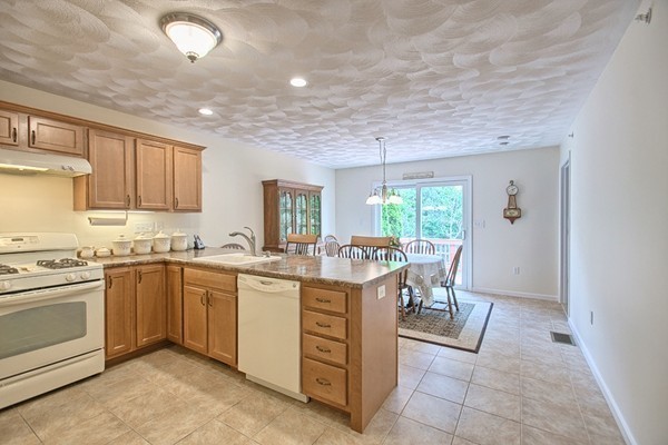 159 Allen Road, Unit 28 Billerica, MA 01821 - Photo 7 of 28 a kitchen with a stove a sink a dining table and chairs
