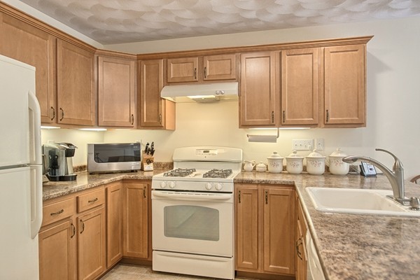 159 Allen Road, Unit 28 Billerica, MA 01821 - Photo 8 of 28 a kitchen with granite countertop a sink stove and cabinets