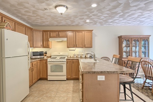 159 Allen Road, Unit 28 Billerica, MA 01821 - Photo 9 of 28 a kitchen with stainless steel appliances granite countertop a refrigerator a stove a sink dishwasher and white cabinets with wooden floor