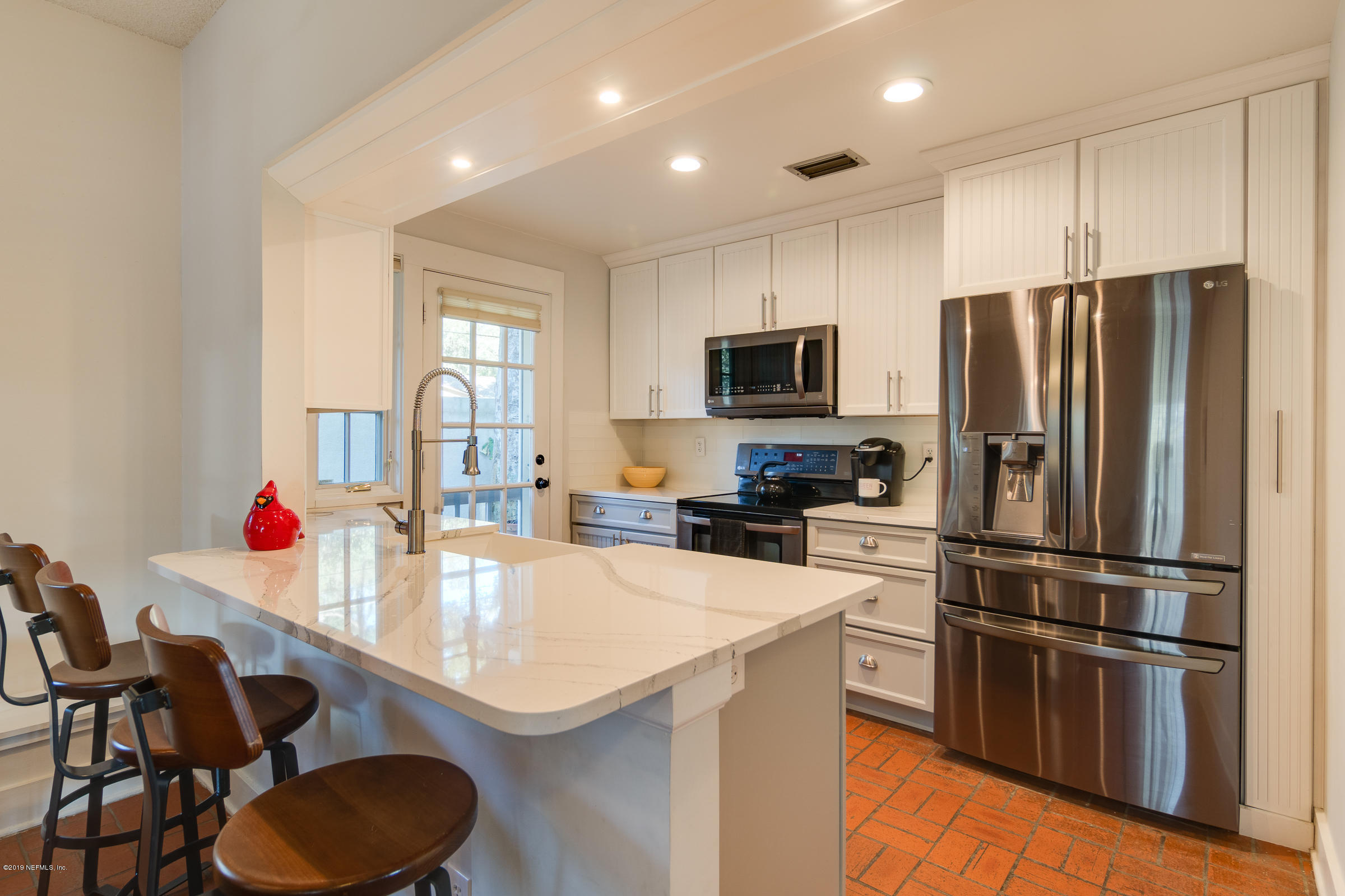 2076 Winterbourne North, Unit 8 Orange Park, FL 32073 - Photo 13 of 36 a kitchen with a sink a kitchen island and stainless steel appliances