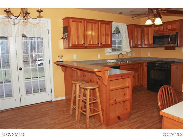 7925 Claystreet Road Ford, VA 23850 - Photo 12 of 13 a kitchen with stainless steel appliances granite countertop a stove a sink dishwasher and microwave with wooden floor