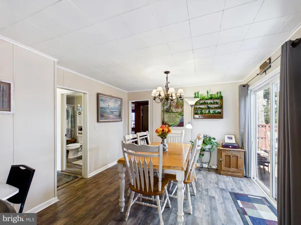 a view of a dining room with furniture a chandelier and wooden floor