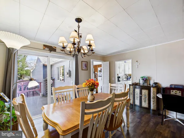 a view of a dining room with furniture a chandelier and wooden floor