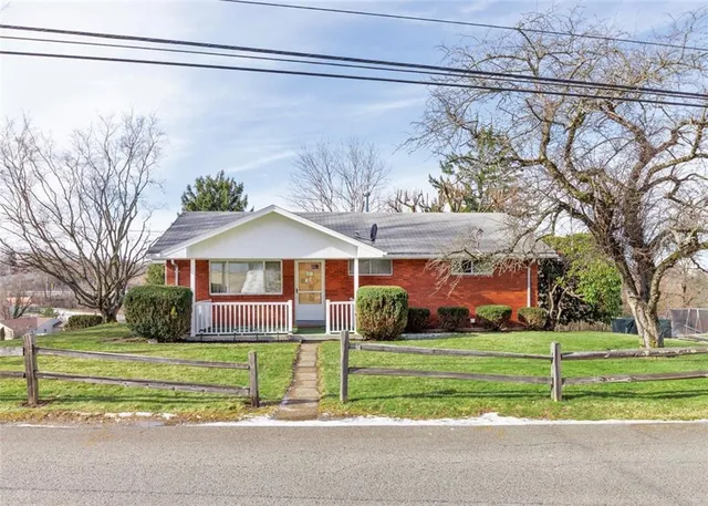 a view of a house with a big yard and large trees