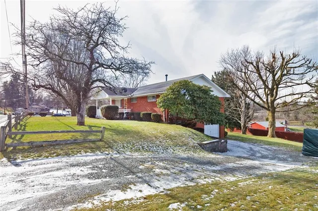 a view of a fountain in front of a house with large trees
