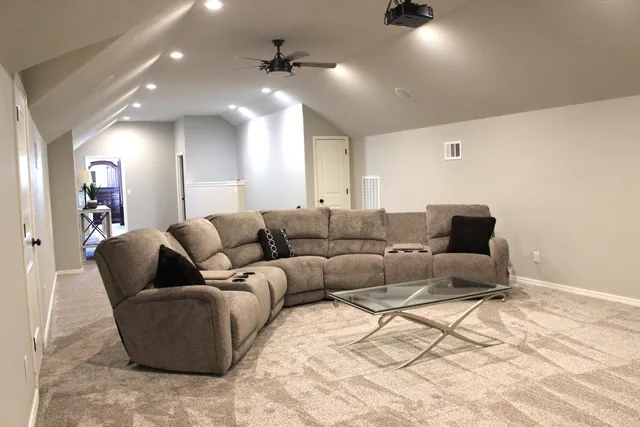 a living room with furniture and a ceiling fan