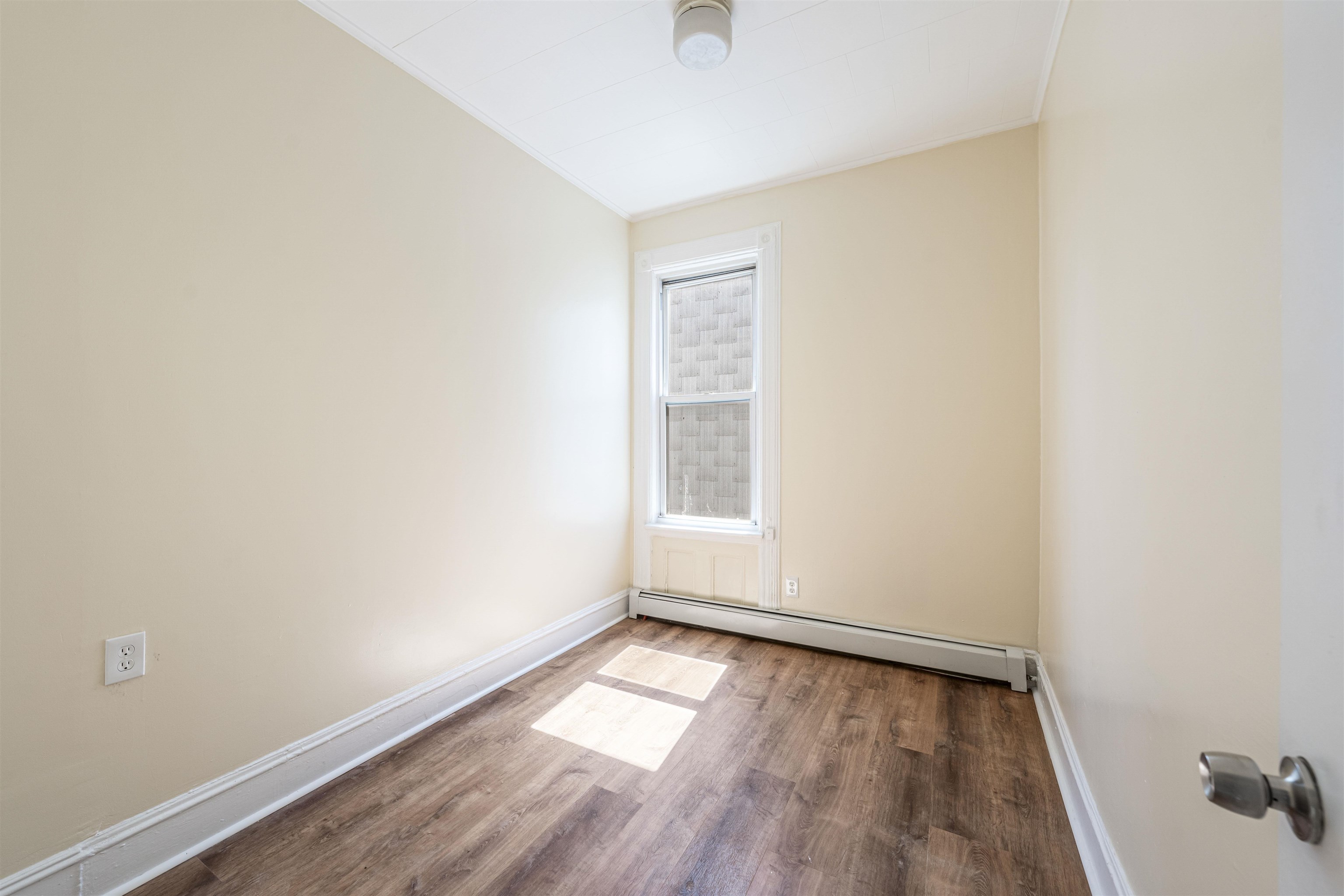 816 20th Street Union City, NJ 07087 - Photo 13 of 15 an empty room with wooden floor and windows