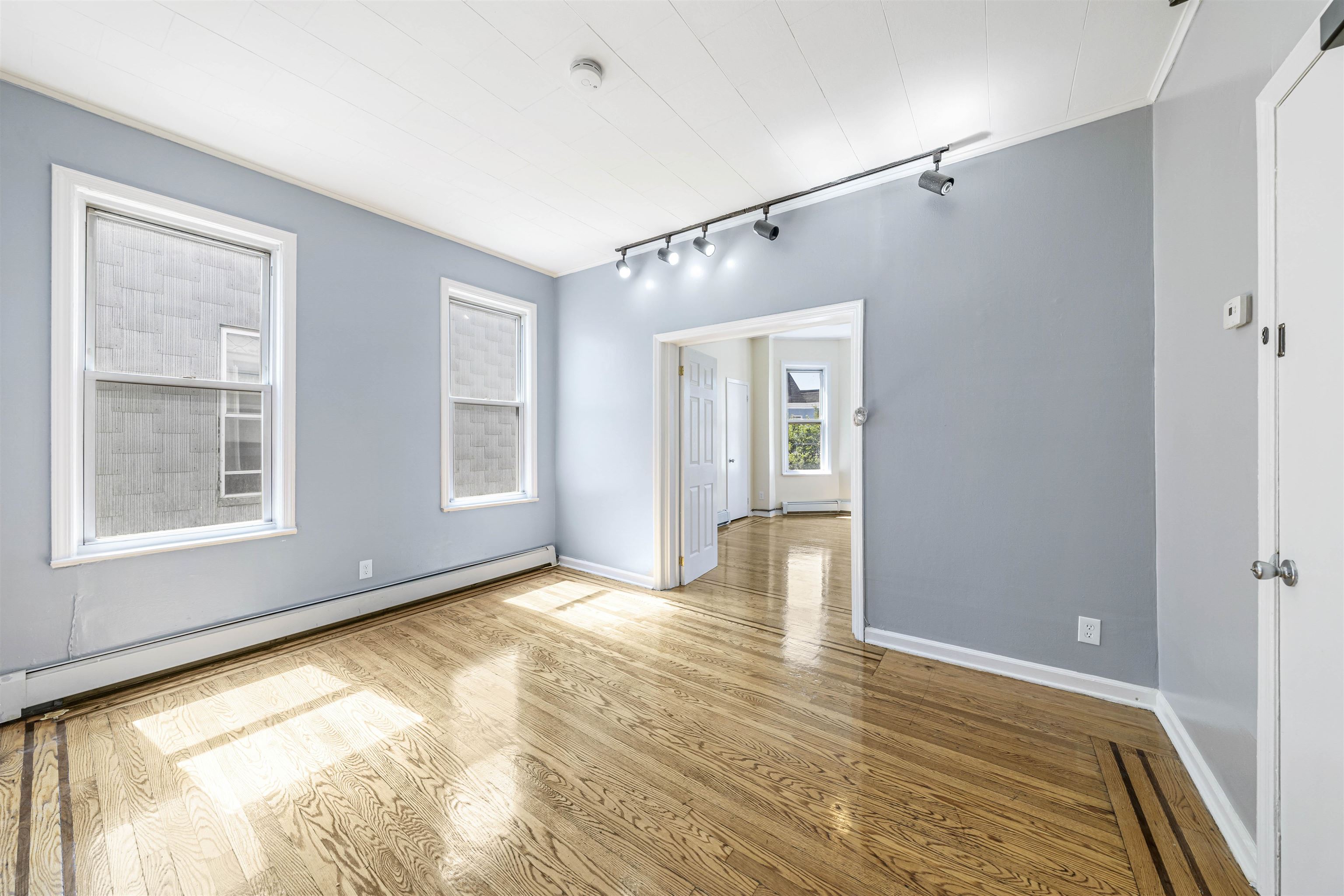 816 20th Street Union City, NJ 07087 - Photo 4 of 15 a view of an empty room with window and wooden floor