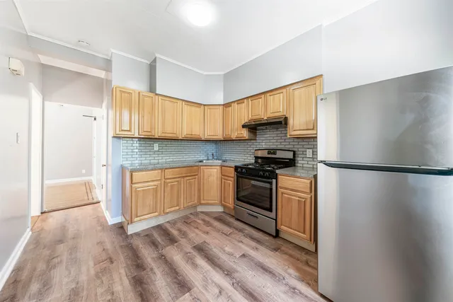 a kitchen with a refrigerator and a stove top oven