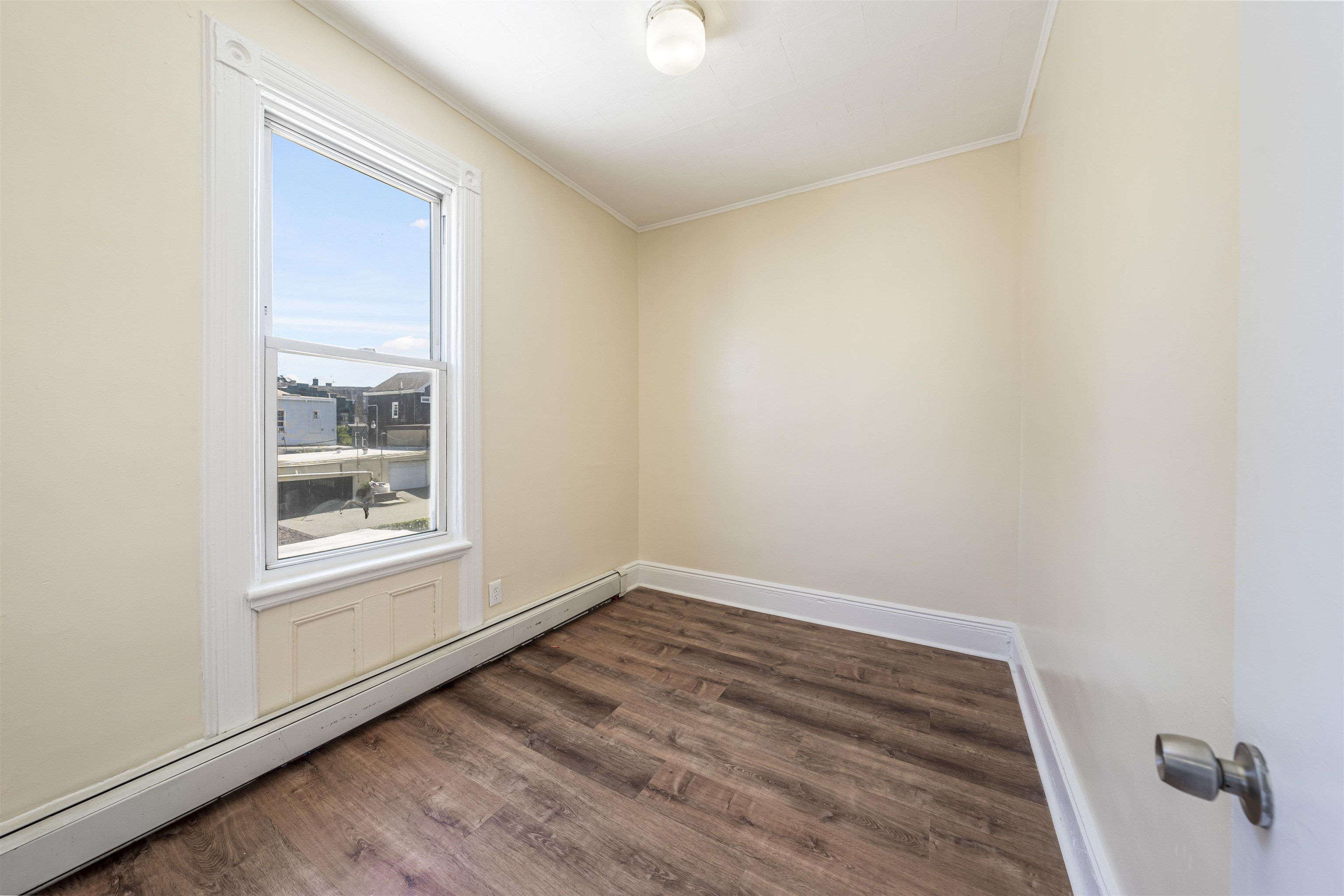 816 20th Street Union City, NJ 07087 - Photo 6 of 15 a view of an empty room with wooden floor and a window
