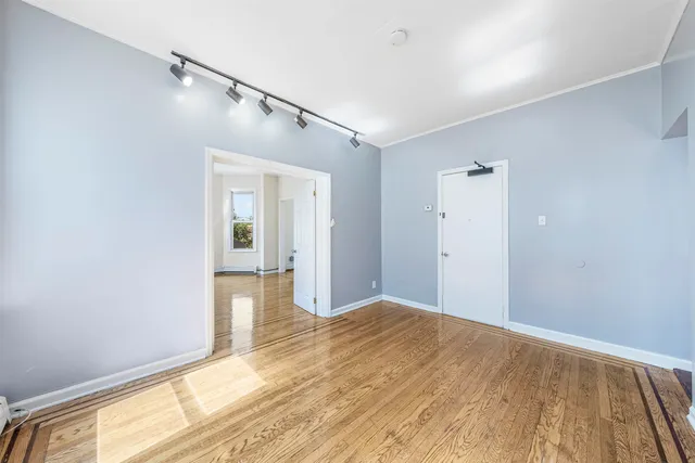 a view of a big room with wooden floor and windows