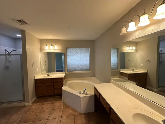 a bathroom with a granite countertop sink mirror and bathtub
