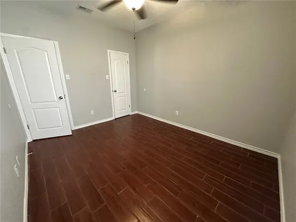 a view of empty room with wooden floor