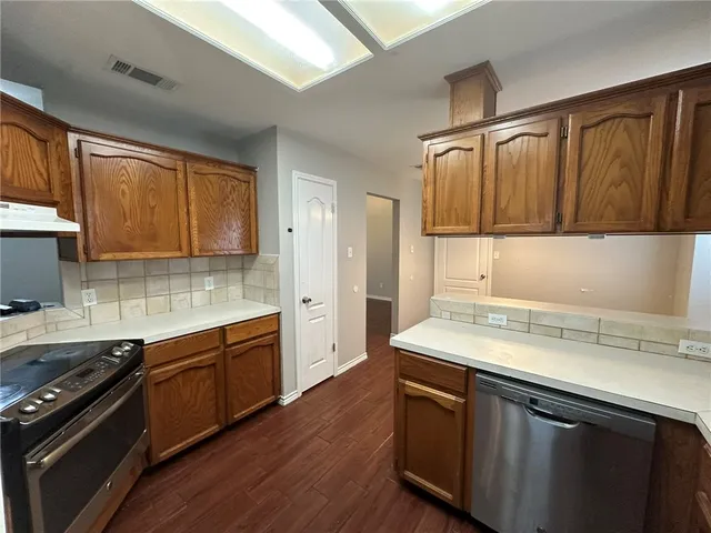 a kitchen with a sink stove top oven and cabinets