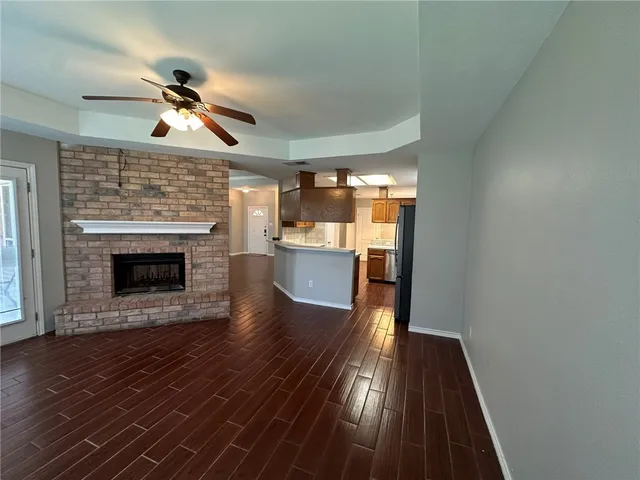 a view of a hallway with wooden floor and a fireplace