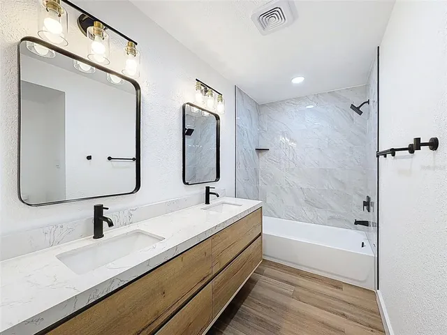 a bathroom with a double vanity sink mirror double and bathtub