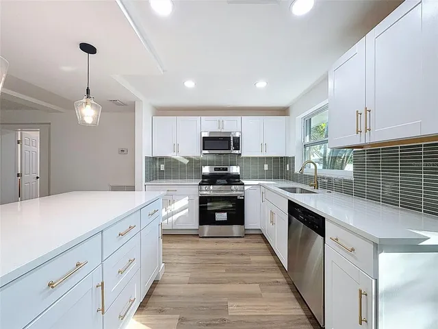 a kitchen with kitchen island granite countertop a stove sink and cabinets