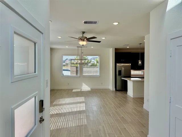 a view of a room with stainless steel appliances wooden floor and living room view