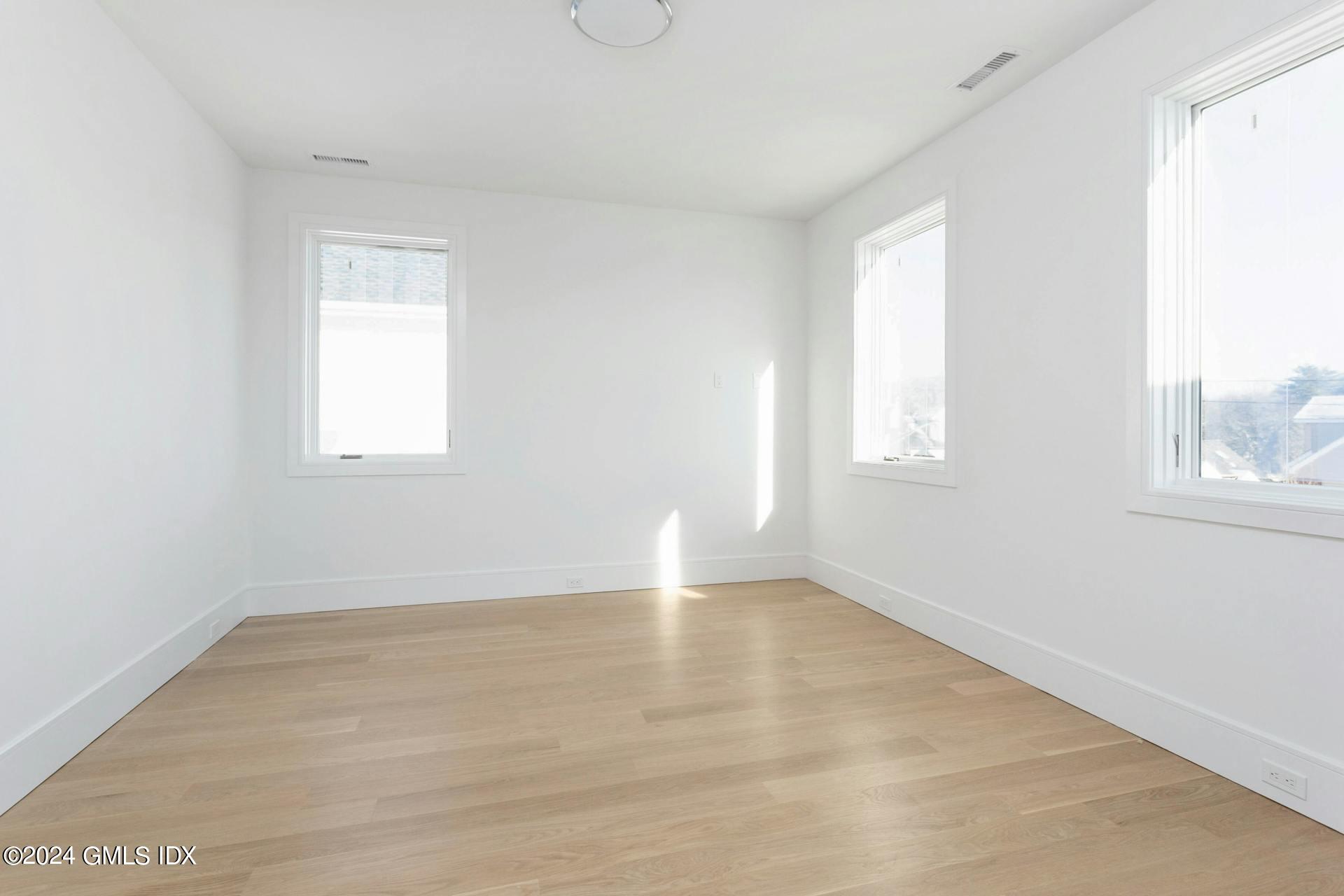 151 East Elm Street Greenwich, CT 06830 - Photo 14 of 29 an empty room with wooden floor and windows