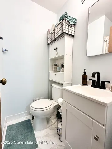 a bathroom with a toilet a sink and a mirror
