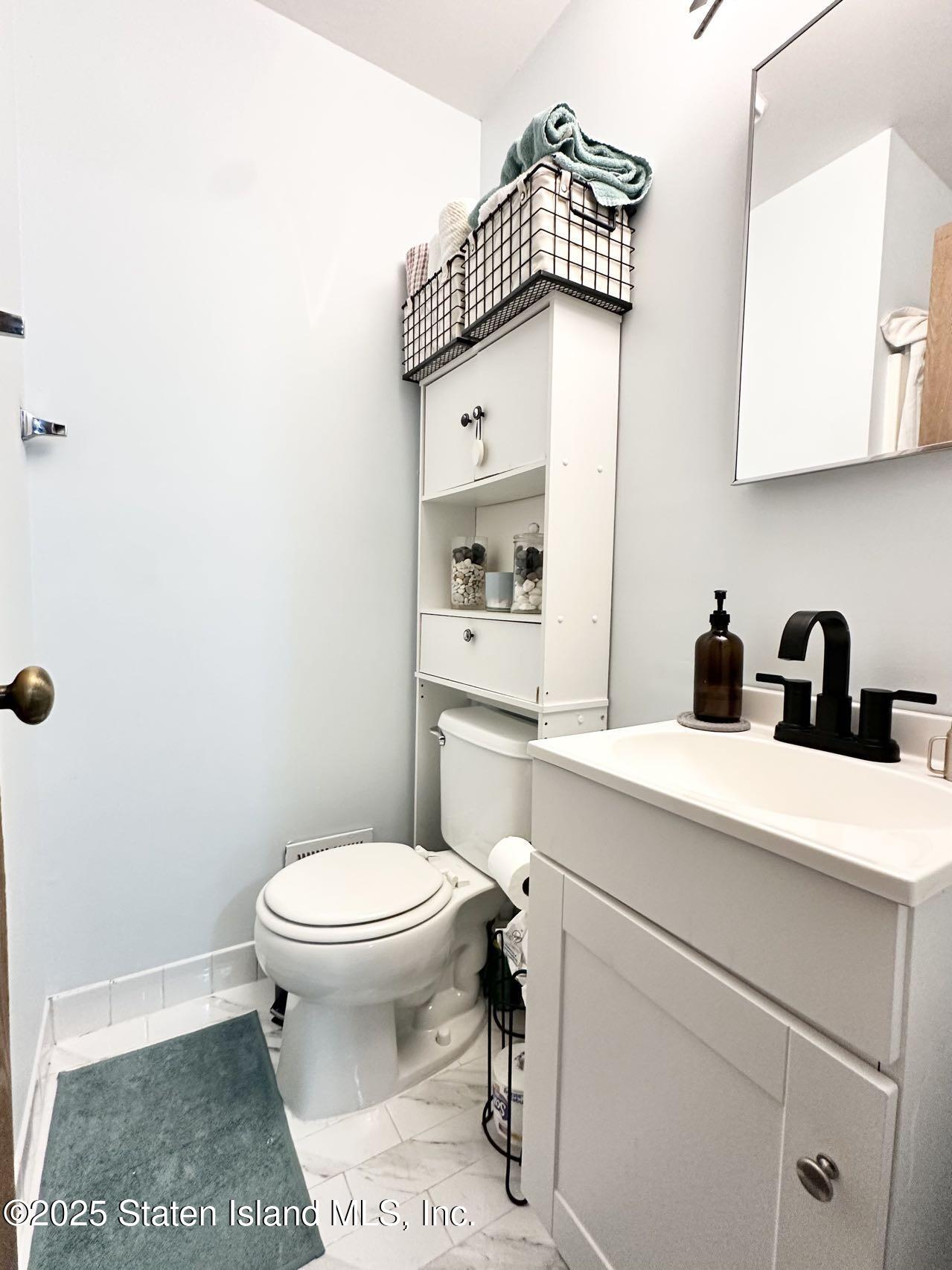 453 Ilyssa Way Staten Island, NY 10312 - Photo 11 of 16 a bathroom with a toilet a sink and a mirror