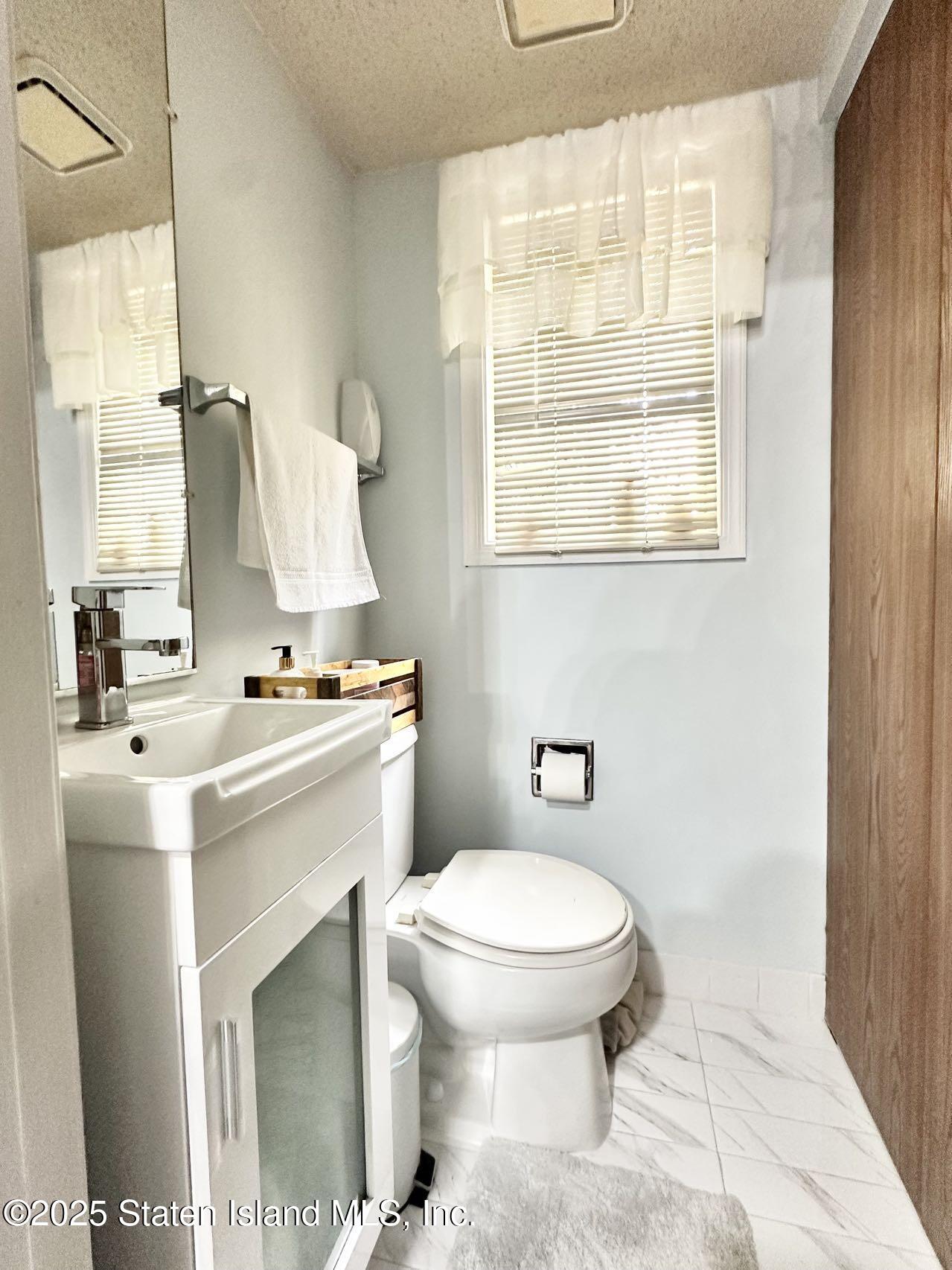 453 Ilyssa Way Staten Island, NY 10312 - Photo 14 of 16 a bathroom with a sink toilet vanity and window