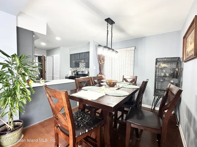 a view of a dining room and livingroom with furniture wooden floor a chandelier