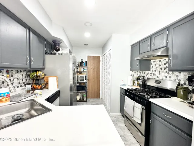 a kitchen with granite countertop a stove and a refrigerator