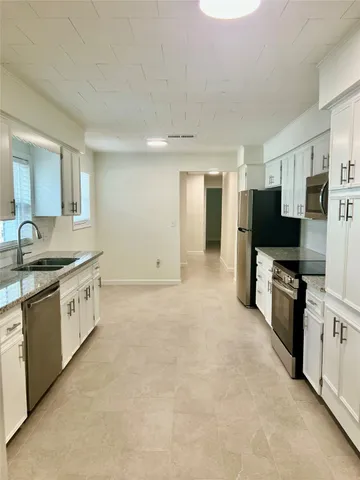 a large kitchen with cabinets and stainless steel appliances