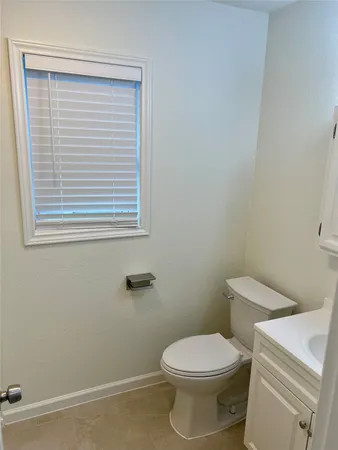 a white toilet sitting next to a small window