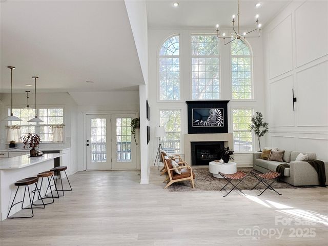a living room with furniture a fireplace and a chandelier