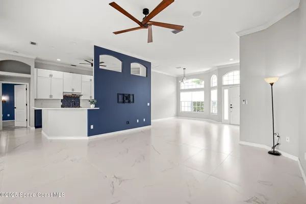 an empty room with windows and ceiling fan