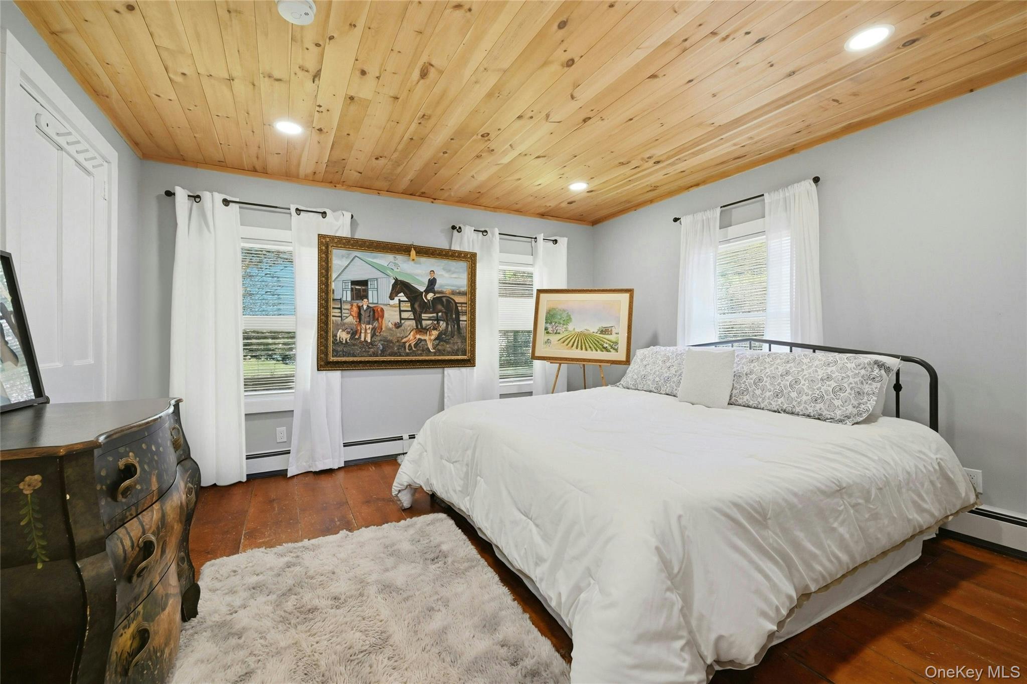 35950 Main Road Cutchogue, NY 11935 - Photo 11 of 23 a bedroom with a large bed and a flat tv screen