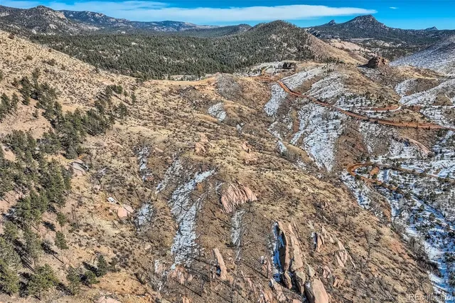 a view of a dry yard with mountains in the background