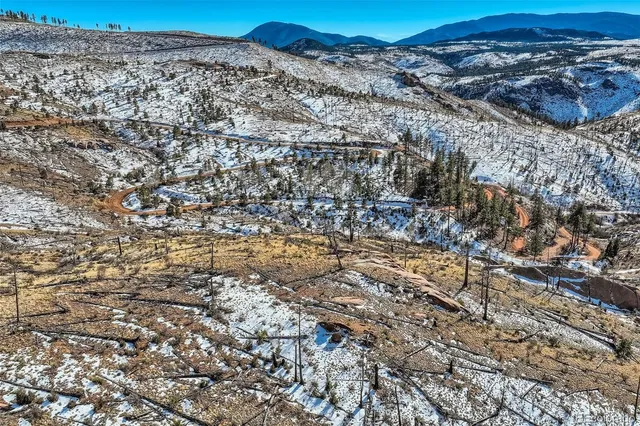 a view of a dry yard with wooden fence