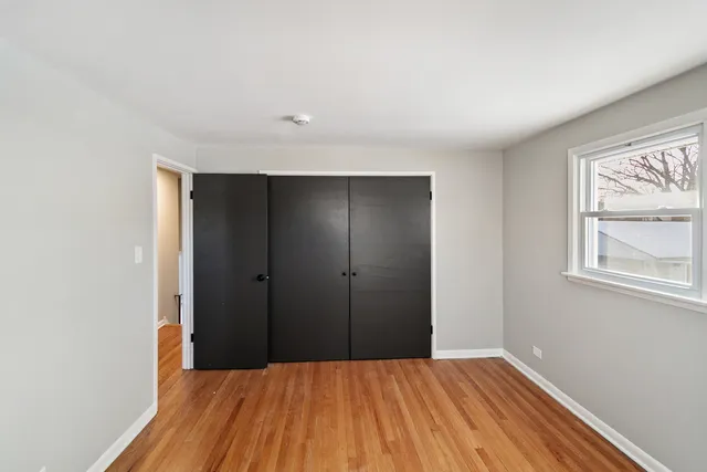 a view of a room with a closet and wooden floor
