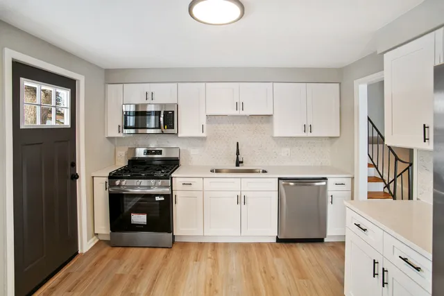 a kitchen with stainless steel appliances granite countertop a stove a sink and a refrigerator