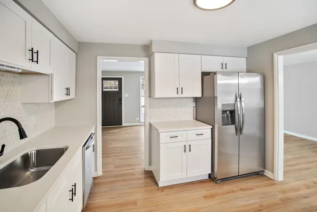 a kitchen with a refrigerator sink and cabinets