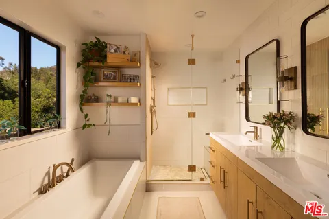 a bathroom with a tub sink and mirror