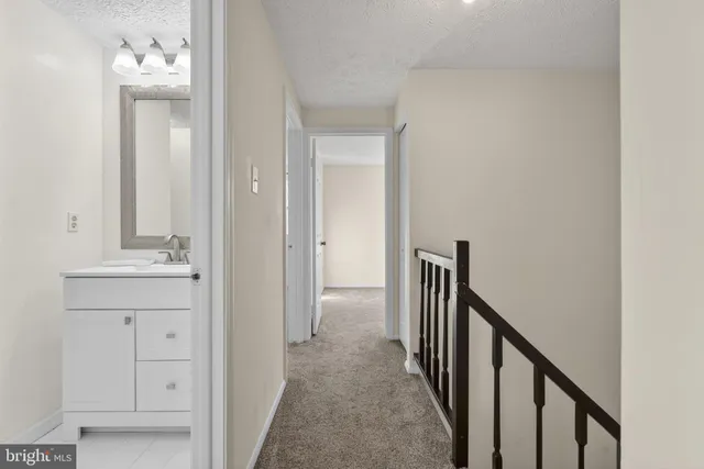 a bathroom with a toilet sink vanity and mirror