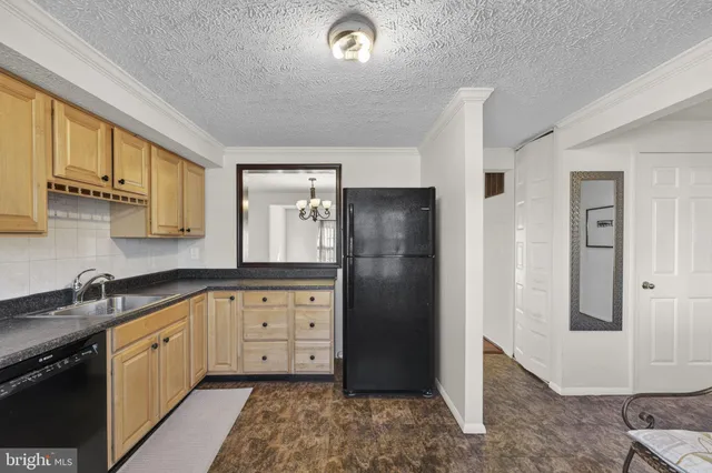 a kitchen with granite countertop a refrigerator and a sink