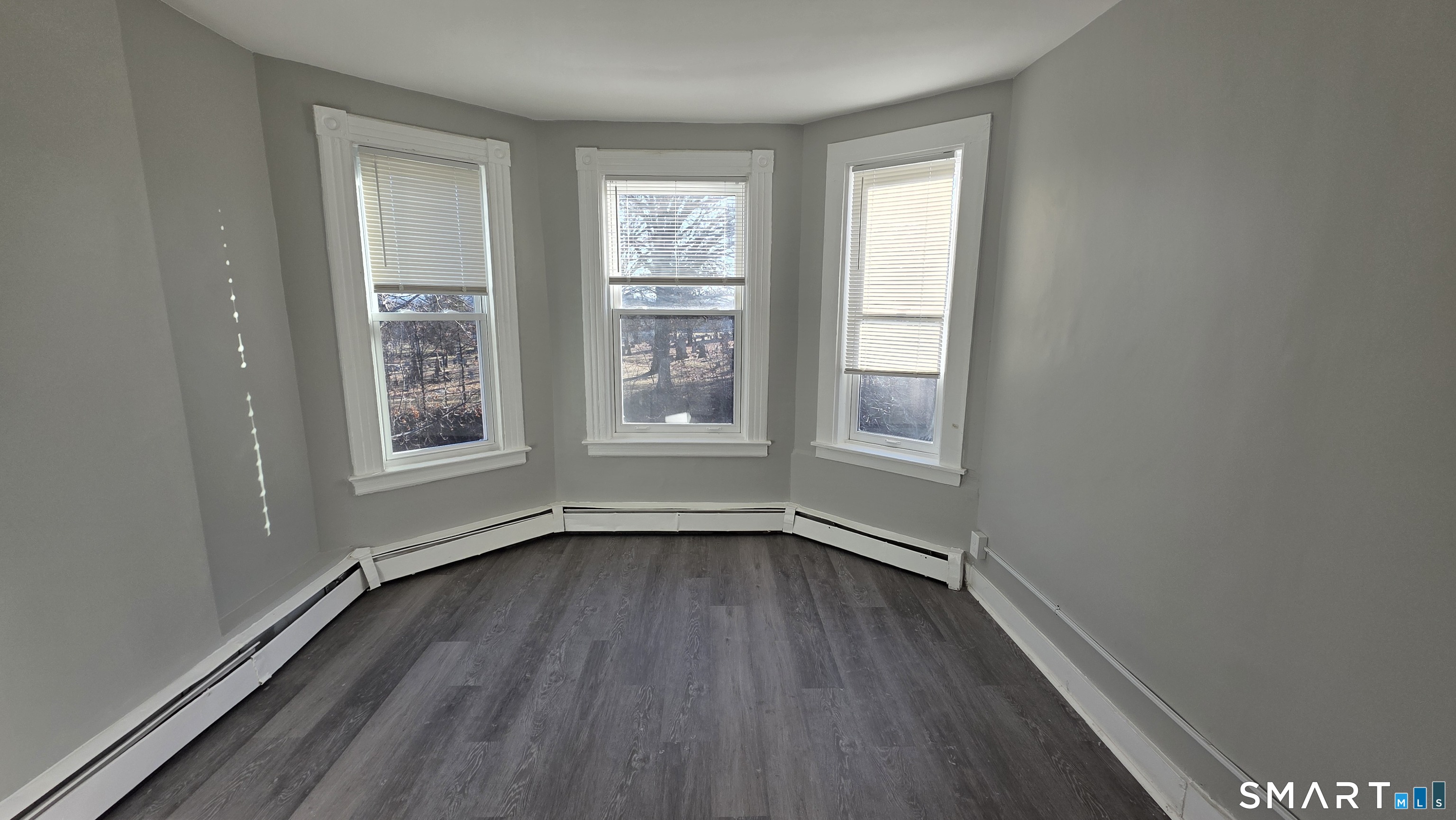 499 Zion Street, Unit 2N Hartford, CT 06106 - Photo 3 of 13 an empty room with wooden floor and windows