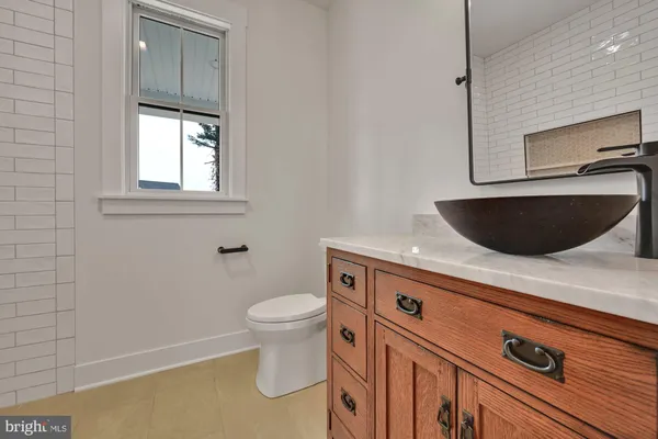 a bathroom with a sink a toilet and mirror