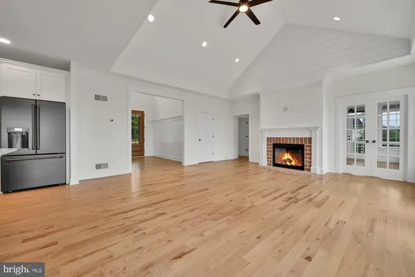 a view of empty room with wooden floor and fireplace