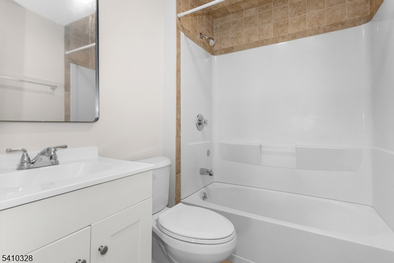 129 Main Street, Unit 3 Bloomingdale, NJ 07403 - Photo 15 of 21 a bathroom with a granite countertop sink a toilet and shower