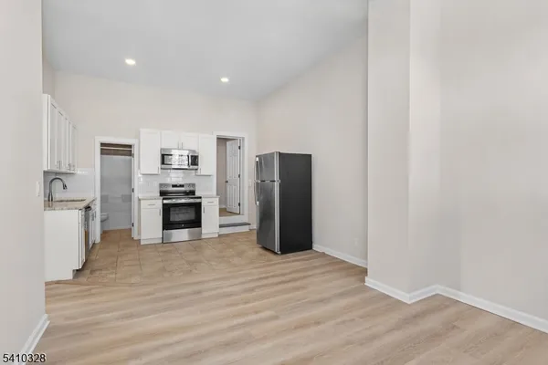 a open kitchen with white cabinets and stainless steel appliances