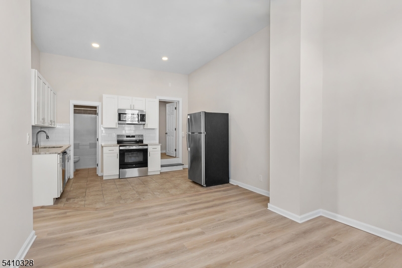 129 Main Street, Unit 3 Bloomingdale, NJ 07403 - Photo 7 of 21 a open kitchen with white cabinets and stainless steel appliances